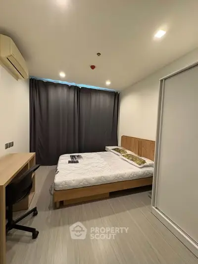 Modern bedroom with sleek design, featuring a comfortable bed, study desk, and air conditioning for ultimate comfort.