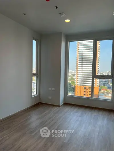 Bright empty room with large windows and city view, perfect for modern living.