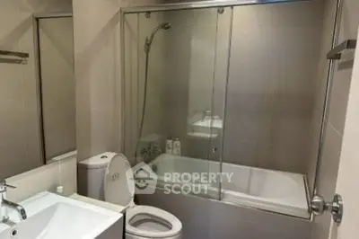Modern bathroom with glass shower and bathtub in sleek design.