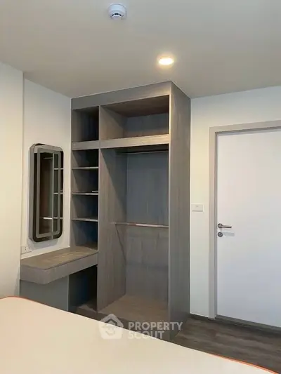 Modern bedroom with built-in wardrobe and vanity in a stylish apartment.
