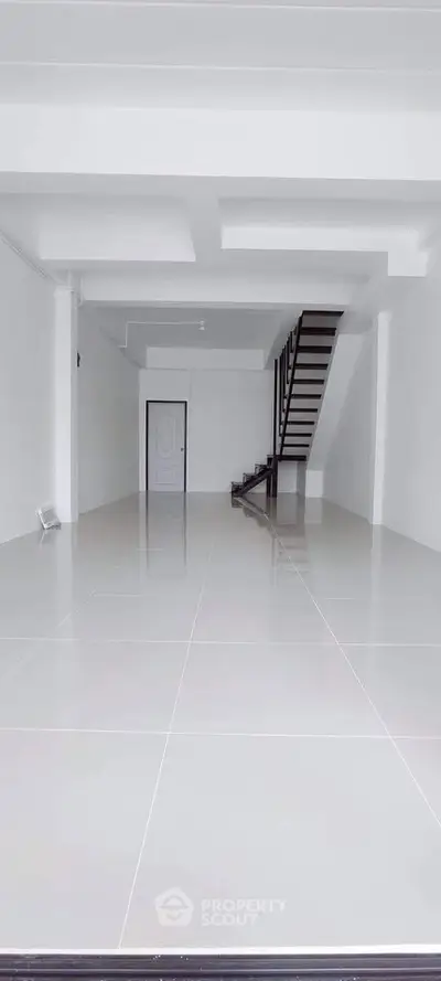 Spacious modern interior with sleek staircase and glossy tiled flooring, perfect for customization.