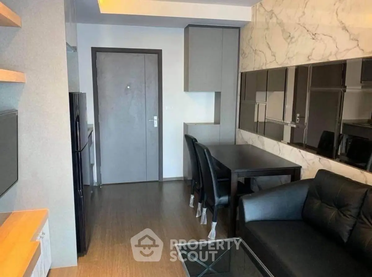 Modern living room with sleek furniture and marble accent wall in a stylish apartment.