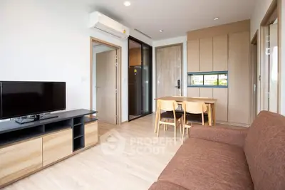 Modern living room with sleek furniture and open kitchen layout in a stylish apartment.