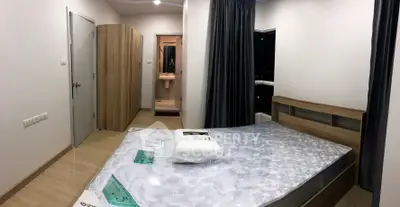 Modern bedroom with wooden furniture and ensuite bathroom in a stylish apartment.