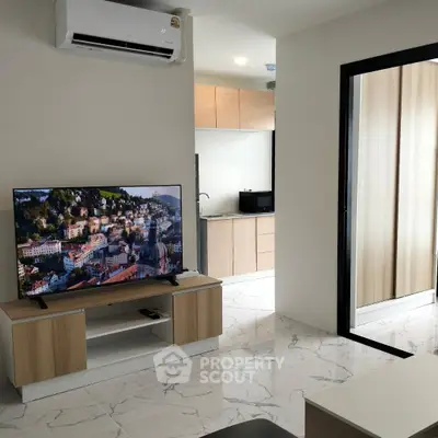Modern living room with sleek TV setup and open kitchen layout