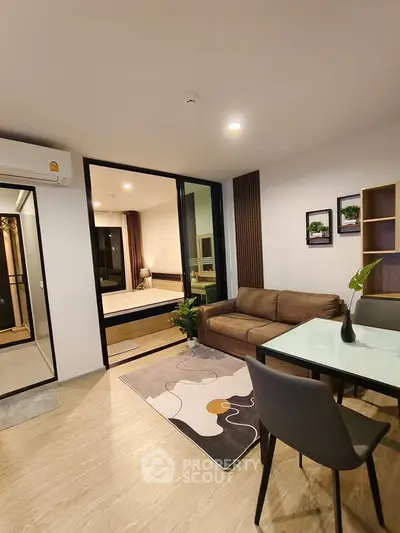 Modern living room with stylish decor and open layout, featuring a cozy sofa and elegant dining area.