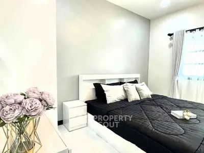 Modern bedroom with stylish decor and natural light, featuring a cozy bed and elegant furnishings.