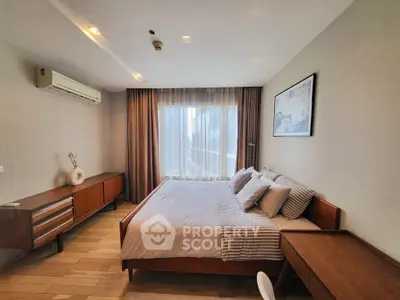 Modern bedroom with large window, stylish furniture, and neutral tones for a cozy ambiance.
