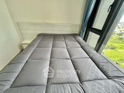 Cozy bedroom with large window offering stunning natural light and views, perfect for relaxation and comfort.
