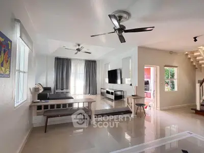Spacious modern living room with ceiling fans and natural light