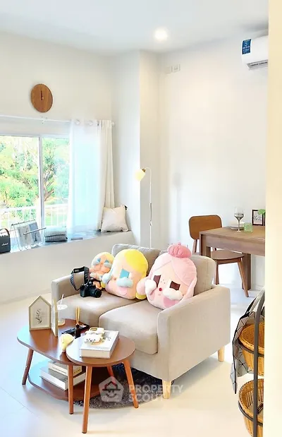 Charming living room with cozy sofa and plush decor, perfect for relaxation.