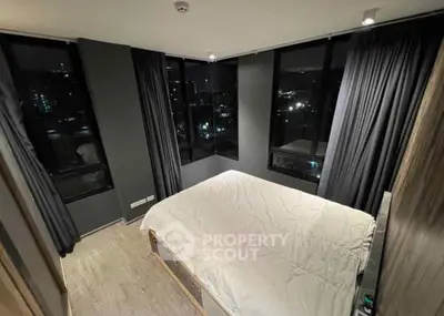 Modern bedroom with large windows offering stunning night city views