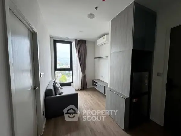 Modern compact living room with large window and sleek furniture