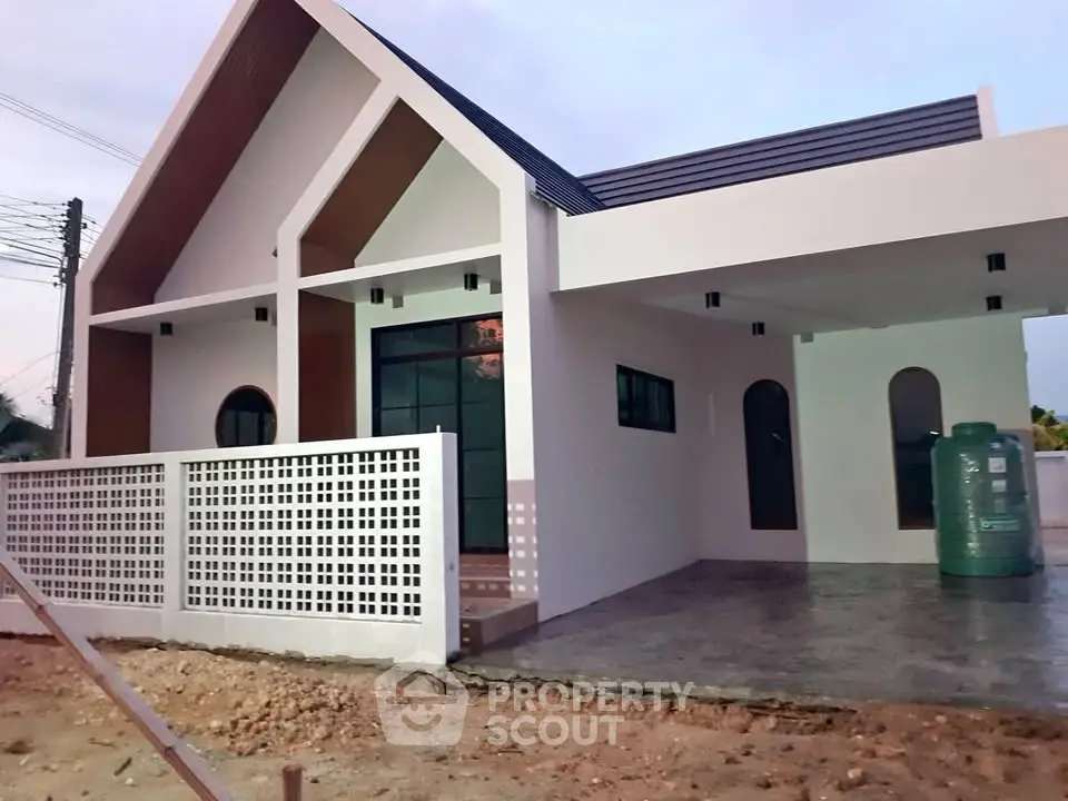 Modern single-story house with unique architectural design and spacious front yard.