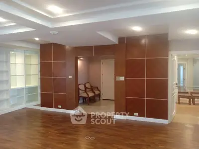 Spacious modern living room with wooden flooring and stylish wall panels.