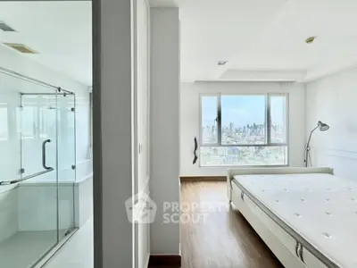 Spacious bedroom with city view and adjacent modern bathroom
