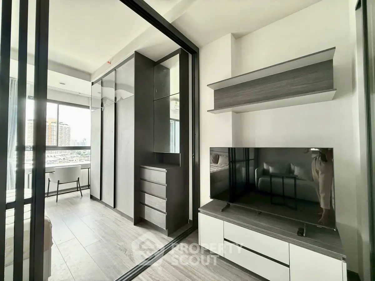 Modern living room with sleek furniture and large windows offering city views