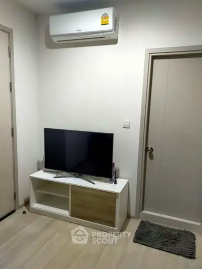 Modern living room with air conditioning and sleek TV setup in a stylish apartment.