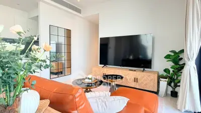 Stylish modern living room with large TV, leather sofa, and elegant decor