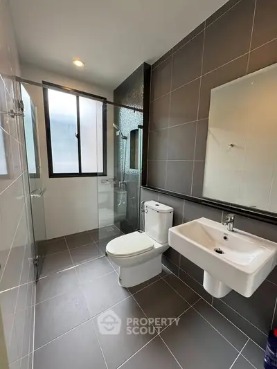 Modern bathroom with sleek fixtures and large window for natural light.