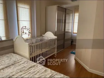 Cozy bedroom with crib and modern wardrobe, perfect for a growing family.