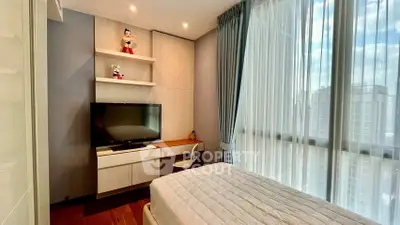 Modern bedroom with large window and built-in desk featuring a TV