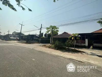 Tranquil suburban street showcasing a row of single-story homes with traditional tiled roofs, lush greenery, and clear blue skies, ideal for peaceful living.