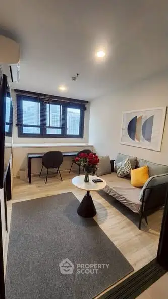 Modern living room with stylish decor and large windows in a cozy apartment.