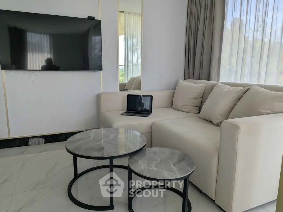 Modern living room with sleek TV, cozy sofa, and stylish marble coffee tables.