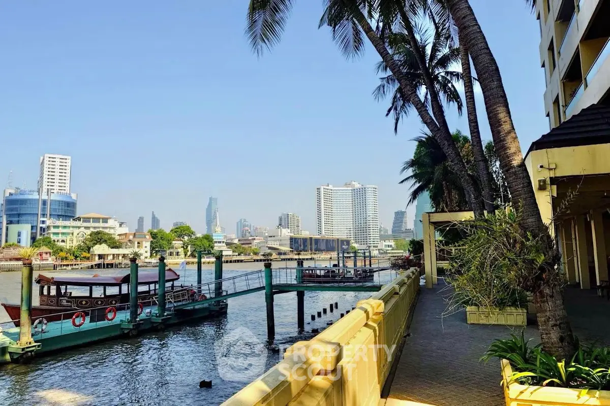 Stunning riverside view with palm trees and city skyline, perfect for luxury waterfront living.