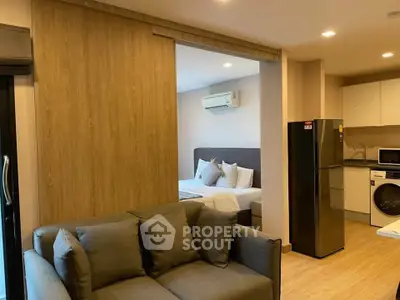 Modern studio apartment with cozy living area, compact kitchen, and comfortable bedroom.