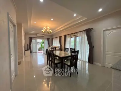 Spacious dining area with elegant chandelier and large windows in modern home