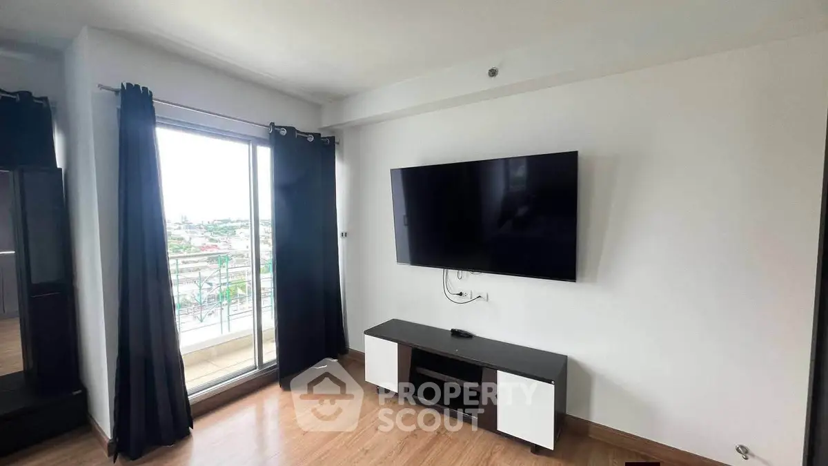Modern living room with balcony view and wall-mounted TV in a stylish apartment.