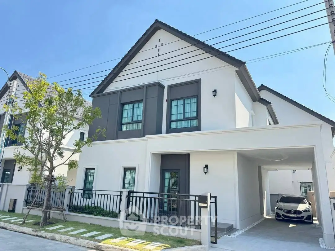 Modern two-story house with carport and landscaped front yard in suburban neighborhood.