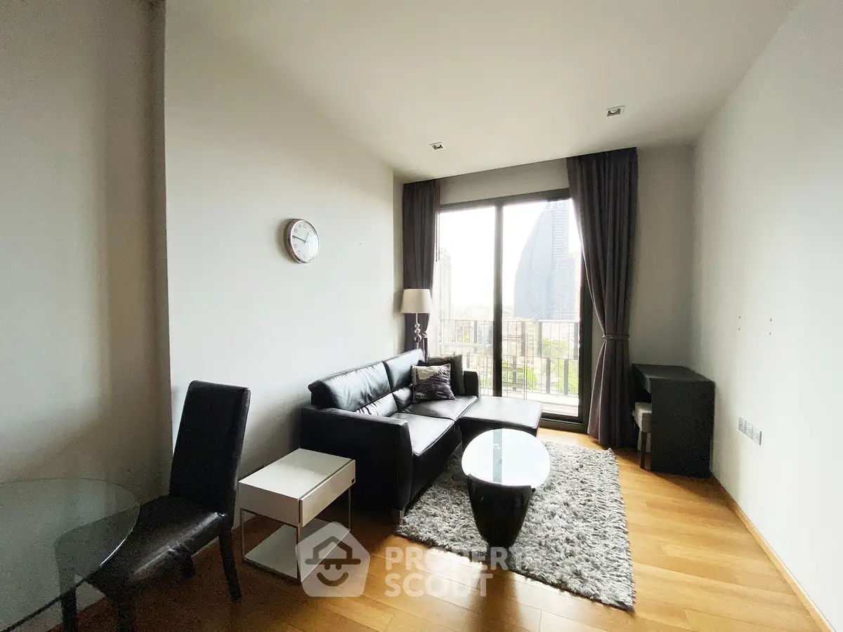 Modern living room with city view, featuring sleek black furniture and wooden flooring.