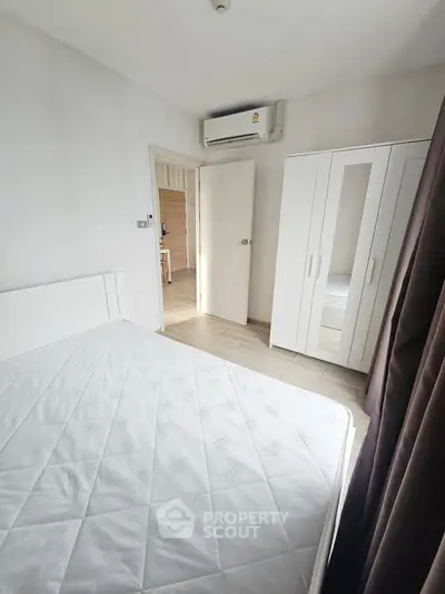 Bright bedroom with white furniture and air conditioning, perfect for a cozy living space.