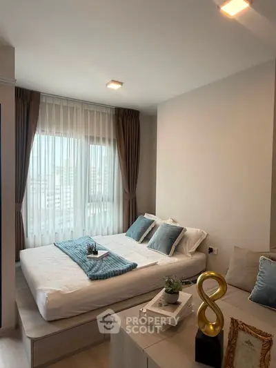 Modern bedroom with cozy decor and large window offering city views
