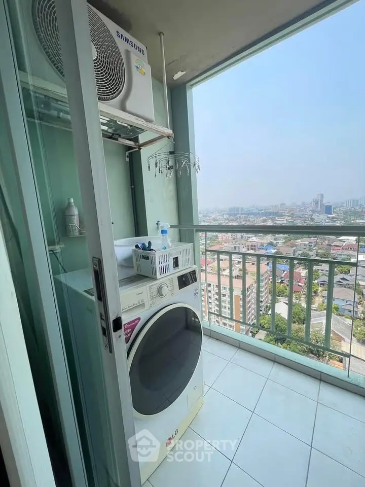 High-rise balcony with washer and city view, perfect for urban living convenience.