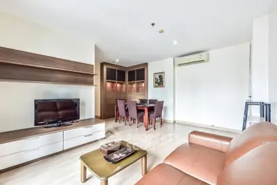 Spacious living room with modern furniture and dining area in a stylish apartment.