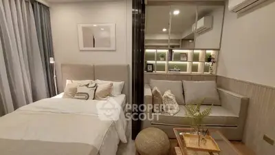 Modern bedroom with cozy living area, stylish decor, and soft lighting in a compact apartment.