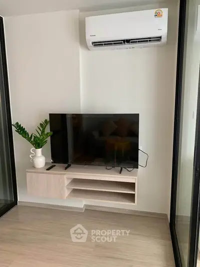Modern living room with sleek TV setup and air conditioning, perfect for cozy relaxation.
