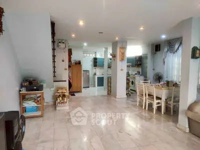 Spacious open-plan living and dining area with modern kitchen and elegant decor.