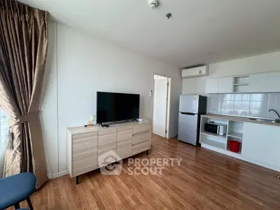 Modern living room with open kitchen, wooden floors, and natural light