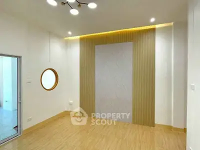 Modern minimalist room with unique circular window and elegant wall paneling.