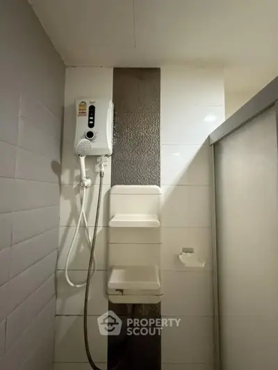 Compact bathroom with modern shower unit and sleek tile design
