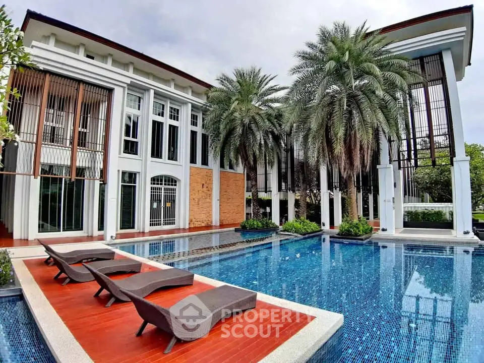 Luxurious modern villa with stunning pool and palm trees, perfect for relaxation and entertainment.