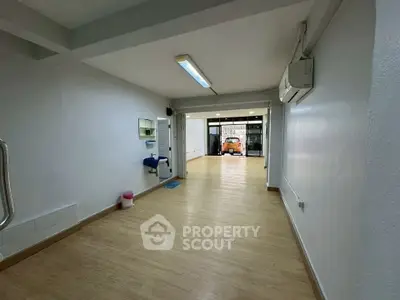 Spacious commercial space with wooden flooring and large front window
