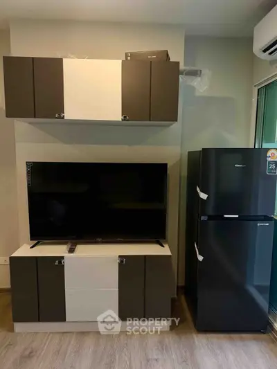 Modern living room with sleek TV unit and refrigerator, perfect for contemporary urban living.