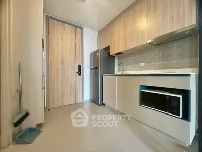 Modern kitchen with sleek cabinetry and stainless steel appliances in a stylish apartment.