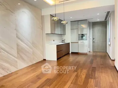Modern kitchen with sleek cabinetry and wooden flooring in a stylish apartment.